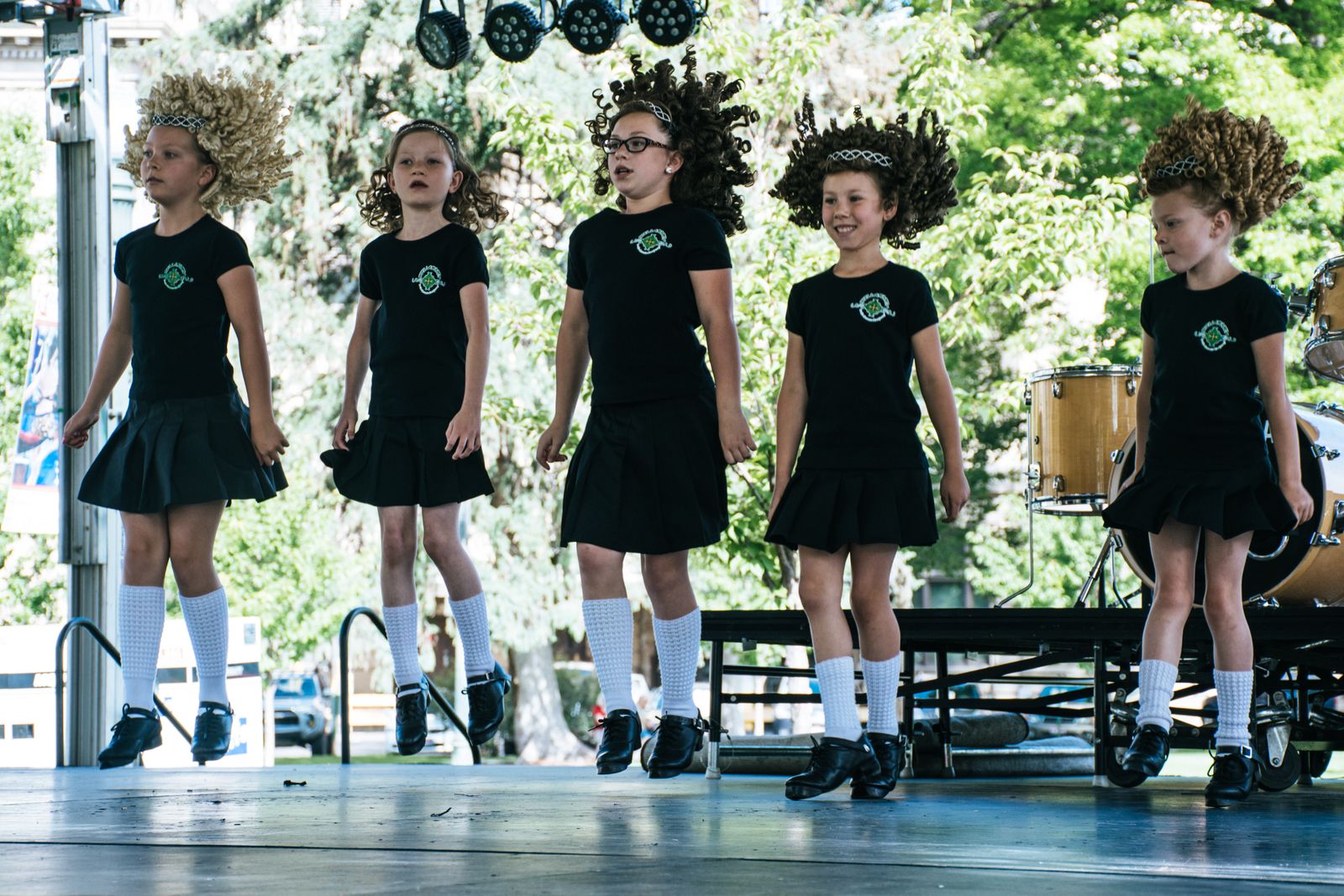 A group of young children performing a dance routine together on an outdoor stage